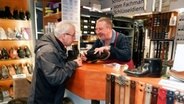 Schuster Rüdiger Block bedient einen Kunden in seinem Geschäft © NDR Foto: Ines Barber