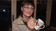 Bruni Peters hällt eine von ihr bemalte Porzellantasse in der Hand. © NDR Foto: Peter Bartelt
