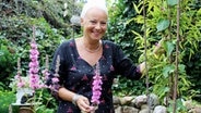 Elvira Berndt steht in Mitten eines blühenden Gartens. © NDR Foto: Andrea Ring