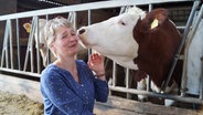 Sabine Möller bekommt ein Küsschen von einer Kuh. © NDR Foto: Robert Tschuschke