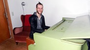 Jörn Bielfeldt sitzt ein einem Klavier und lacht © NDR Foto: Ines Barber