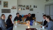 Sergej Tcherepanov sitzt mit Mitgliedern des Vokalkreises der Kirche am Tisch © NDR Foto: Nadine Dietrich