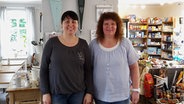 Julia Stricker (l.) und Kerstin Braun stehen in ihrem Laden "de Lütte Loden" in Hollingstadt. © NDR Foto: Cassandra Jane Arden