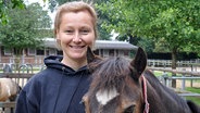 Sandra Stolze steht in Holstenniendorf neben einem Pony. © NDR Foto: Jörn Schaar