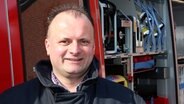 Heiko Trost aus Bröthen vor einem Feuerwehrwagen. © NDR Foto: Hauke Bülow