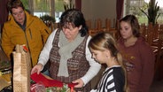 Gabi Petersen (2.v.l.) aus Eisendorf bastelt mit Kindern an einem Tisch © NDR Foto: Frank Hajasch