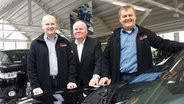 Die Top Schleswig-Holsteiner Thorsten, Klaus und Thomas Wischnat posieren in ihrem Autohaus. © NDR Foto: Thorsten Philipps