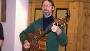 Bernd Jochimsen spielt auf der Gitarre ein Lied. © NDR Foto: Peer-Axel Kroeske