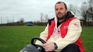 Michael Köpke sitzt auf einem Kettcar auf einer Wiese © NDR Foto: Janine Artist