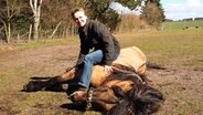 Die Top Schleswig-Holsteinerin aus Göttin ist Pferdedompteurin Marain Schmiedehausen liebt Tiere über Alles. Hier liegt sie auf einem Pferd. © NDR Foto: Thorsten Philipps