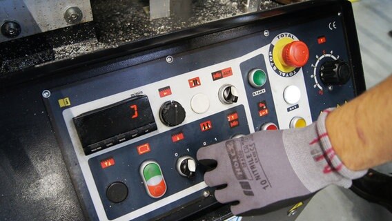 EIne Hand stellt einen Regler an einem technischen Gerät ein, das zu einer großen Säge gehört. © NDR Foto: Hauke von Hallern