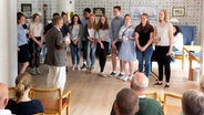 In der Ferring Stiftung in Alkersum auf Föhr stellen Schüler gemeinsam mit Volkert Faltings ihr neues Buch vor. © NDR Foto: Meike Riewerts