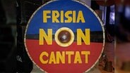 Eine mittelalterliches Schild zeigt das Logo der Band Frisia non Cantat in den friesischen Farben Gold, rot und Blau. © NDR Foto: Karin Haug