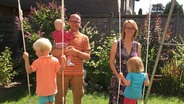 Familie Krelle mit ihren drei Kindern stehen in einem Garten. © NDR Foto: Elin Hinrichsen