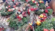 Gebundene Fruchtkränze liegen ausgebreitet auf einem Tisch. © NDR Foto: Karin Haug