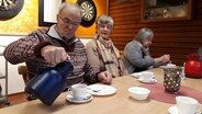 Zwei ältere Frauen und ein Mann trinken gemeinsam Kaffee. © NDR Foto: Karin Haug
