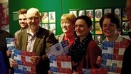 Zwei Männer und drei Frauen stehen beieinander und halten Flyer in den Händen und lächeln. © NDR Foto: Lornz Lorenzen