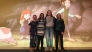 Vier Kinder stehen im Traum-Kino in Kiel vor der Leinwand auf der ein Zeichentrickfilm zu sehen ist. © NDR Foto: Stephanie Bommes Alvarez
