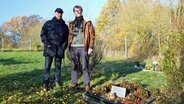 Ulrich Moeller und Ulrich Gradert stehen auf einem Friedhof für Tiere. © NDR Foto: Andrea Ring