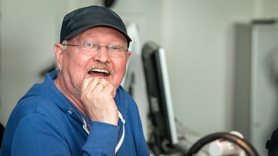 Torfrocksänger und Buchautor Klaus Büchner sitzt lachend im NDR Sendestudio. © NDR Foto: Janis Roehlig