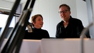 Im Radiostudio stehen die Hebamme Astrid Volkerts und Moderator Jan Malte Andresen vor den Mikrofonen. © NDR Foto: Anna Baake