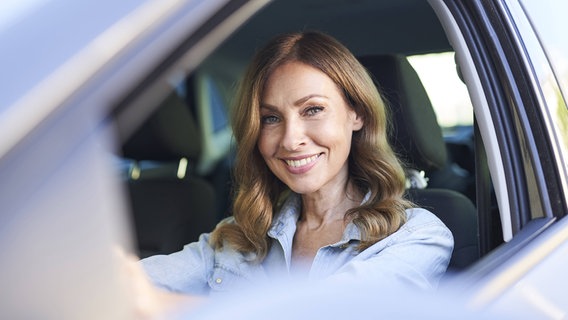 Eine Frau sitzt am Steuer eines Autos. © imago images Foto: Westend61