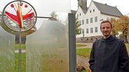 Bruder Johannes aus dem Kloster Nütschau steht vor dem Kloster und lächelt © NDR Foto: Mechthild Mäsker