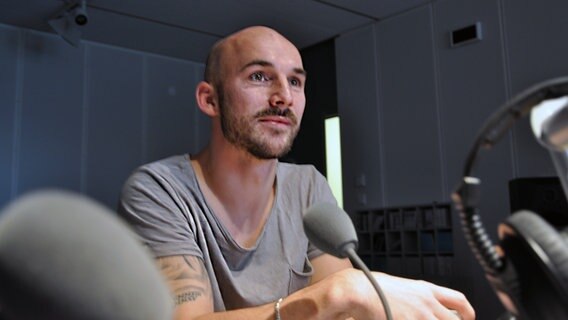 Patrick Herrmann sitzt in einem Radiostudio. © NDR Foto: Jannis Lippisch