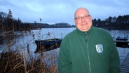 Jan Meister steht vor einem See in Leezen. © NDR Foto: Janine Artist