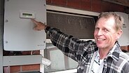 Bernd Rohwedder zeigt stolz den Wechselrichter seiner Solaranlage. © NDR Foto: Janine Artist