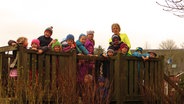 Angelika Lüthje posiert mit vielen Kindern aus Esgrus. © NDR Foto: Pee-Axel Kroeske