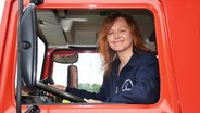 Eine rothaarige Frau sitzt am Steuer eines Feuerwehrautos. © NDR Foto: Katrin Bohlmann