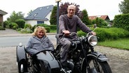 Ein Mann sitzt auf einem Motorrad mit einem Beiwagen. In dem Beiwagen sitzt eine Frau. Beide schauen in die Kamera. © NDR Foto: Jörn Schaar