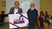 Manfred Tönsing wird im Borgwedeler Dörpshus für seinen Einsatz für den Ortskultur-Ring geehrt  