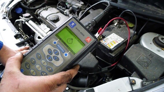 Ein Mechaniker testet eine Autobaterie mit einem Testgerät © NDR Foto: Juliane Thomas