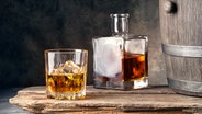 Ein Glas mit Whiskey neben einem Holzfass © fotolia Foto: alexlukin