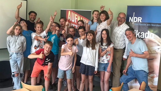 Schülerinnen und Schüler mit Florian Jakobsen (li, mit Mütze), Marko Pauli (rechts, hellblaues Shirt) und Jörgpeter v. Clarenau (im hellen Hemd) © NDR 