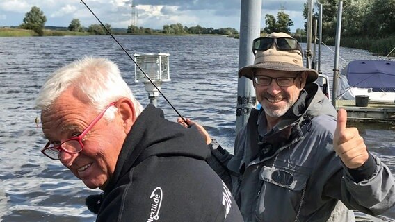 Heinz Galling und Horst Hennings (vorn) stehen gemeinsam auf einem Boot. © NDR Foto: Hauke Sievers