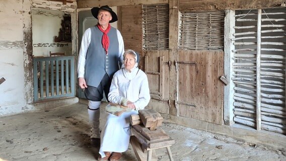 Ein älteres Paar in historischer Kleidung befindet sich in einem Hühnerstall. © Dr. Julia Daum Foto: Dr. Julia Daum