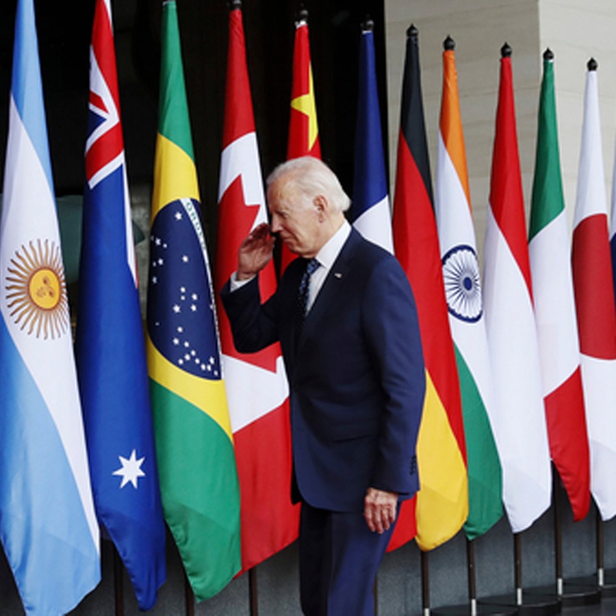 US-Präsident Joe Biden geht während des G20-Gipfels in Indonesien an den Flaggen der Teilnehmerländer vorbei. © dpa Foto: Mast Irham