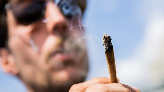 Ein Mann raucht bei einer Demonstrationen einen Joint mit Medizinalcannabis. © Picture Alliance Foto: Christoph Soeder