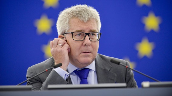 Der polnische EU-Politiker Ryszard Czarnecki (54) hält sich während einer Sitzung den Übersetzungsknopf ans Ohr. © European Union 2017 Foto: Genevieve ENGEL