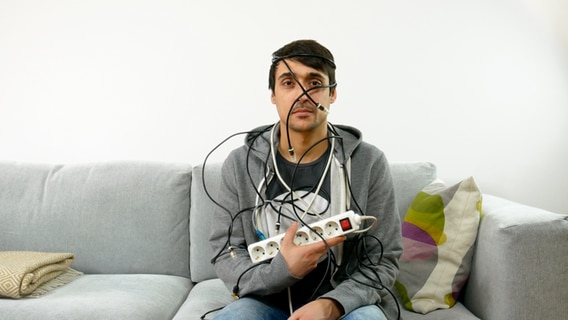 Mann auf einem Sofa mit Kabeln © NDR Foto: Johannes Groß