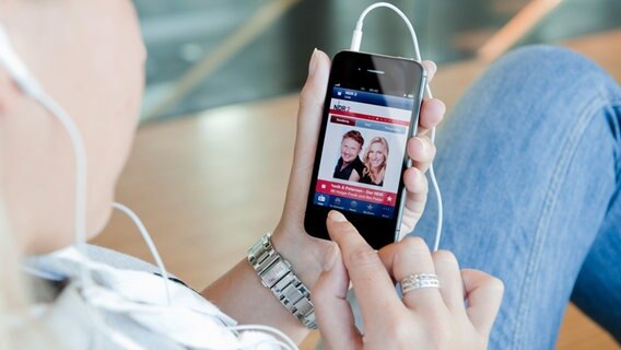Eine Hand bedient ein Smartphone mit der NDR Radio App  Foto: AR