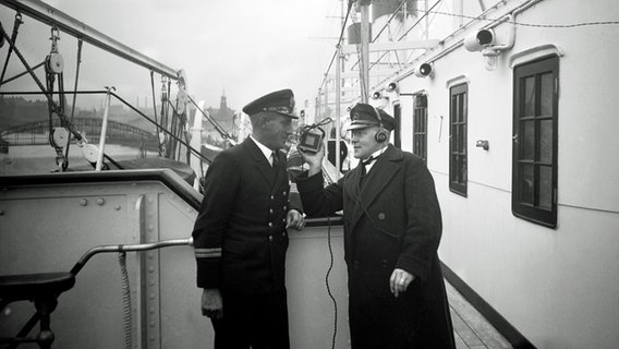 Kurt Esmarch (r.), Sprecher des "Hafenkonzerts", bei einem Interview auf der "Cap Arcona" 1931. © NDR 