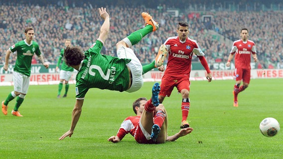 Werders Santiago Garcia fliegt durch die Luft, gefoult von HSV-Profi Dennis Diekmeier (unten) © Witters 