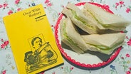 Gurkensandwiches und Oscar Wildes Buch "Bunbury" von "Reclam" beim eat.READ.sleep Folge 9 © NDR 