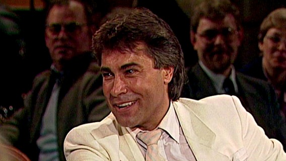 Sänger Roy Black trägt in der NDR Talk Show am 26. April 1985 einen weißen Anzug.  
