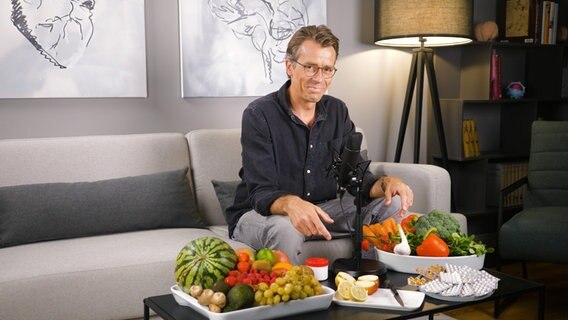 Dr. Johannes Wimmer sitzt auf einem Sofa. © Screenshot 