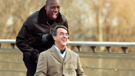 Philippe (François Cluzet) genießt die unkomplizierte Art seines neuen Pflegers Driss (Omar Sy, li.). © NDR/Degeto/Quad Productions 
